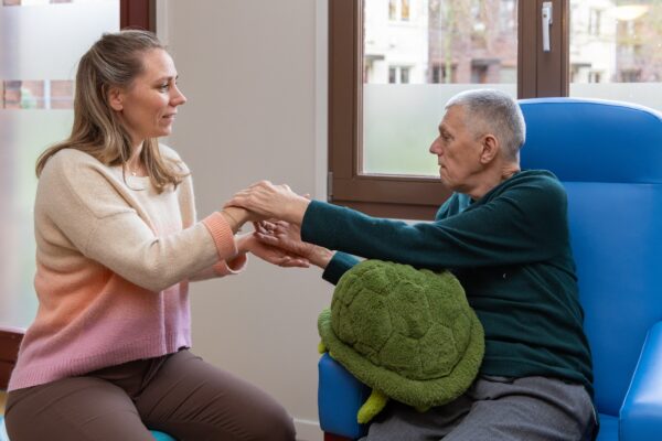 Begeleider en cliënt voelen elkaars hand