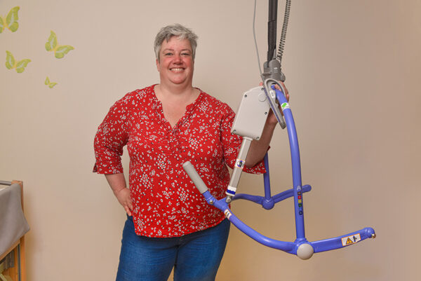 Behandelaar medische dienst naast bed met hulpmiddel