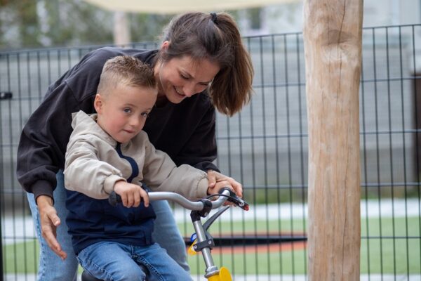 Begeleider helpt client met fietsen