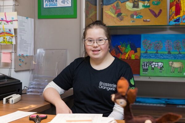 Cliënt is bezig met een creatief project tijdens dagbesteding