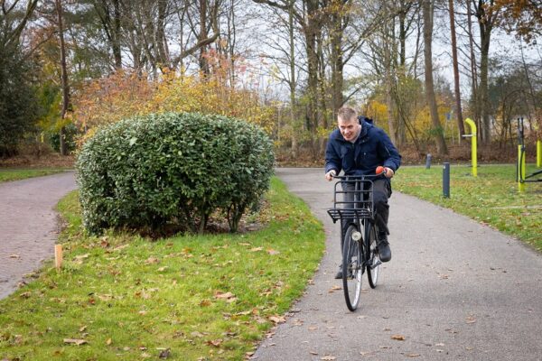 Cliënt op de fiets op het terrein van de Hartekamp Groep in Heemstede