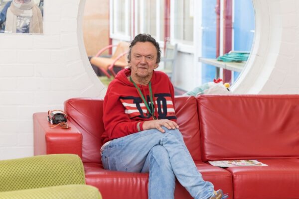 Een oudere cliënt heeft een moment van rust op de bank tijdens de dag