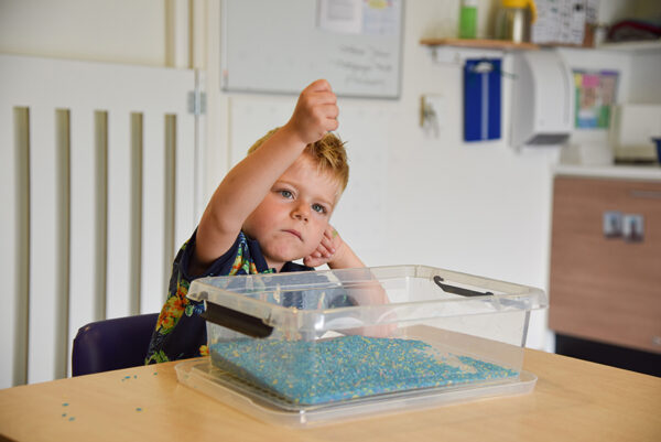 jongetje speelt met kraaltjes op Duinhuis