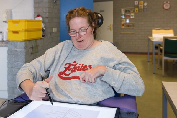 Cliënt is aan het tekenen tijdens dagbesteding