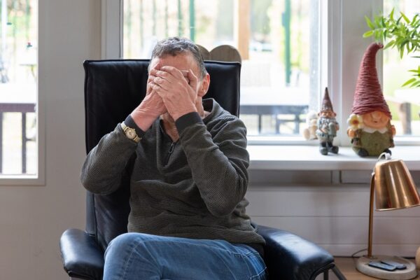 Cliënt slaat handen voor gezicht